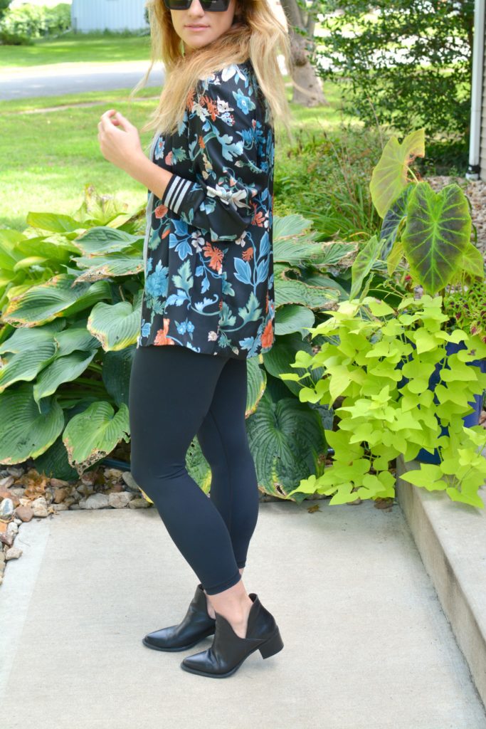 Ashley from LSR wearing a floral bomber jacket from H&M with black leggings and ankle boots