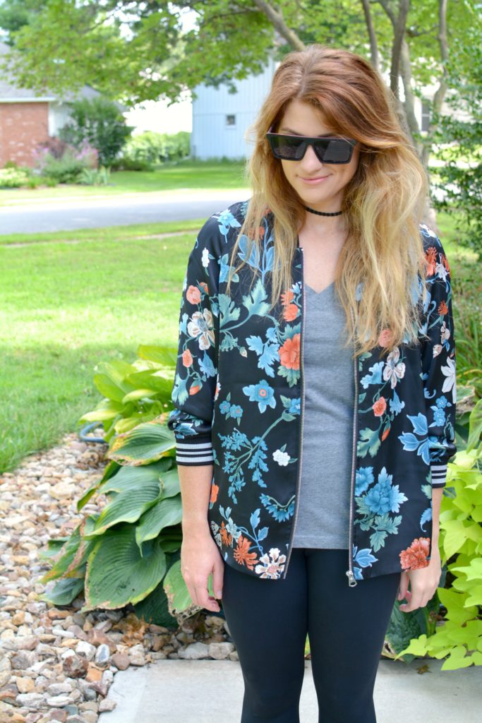 Ashley from LSR wearing a floral bomber jacket from H&M with a gray t-shirt and Proof sunglasses