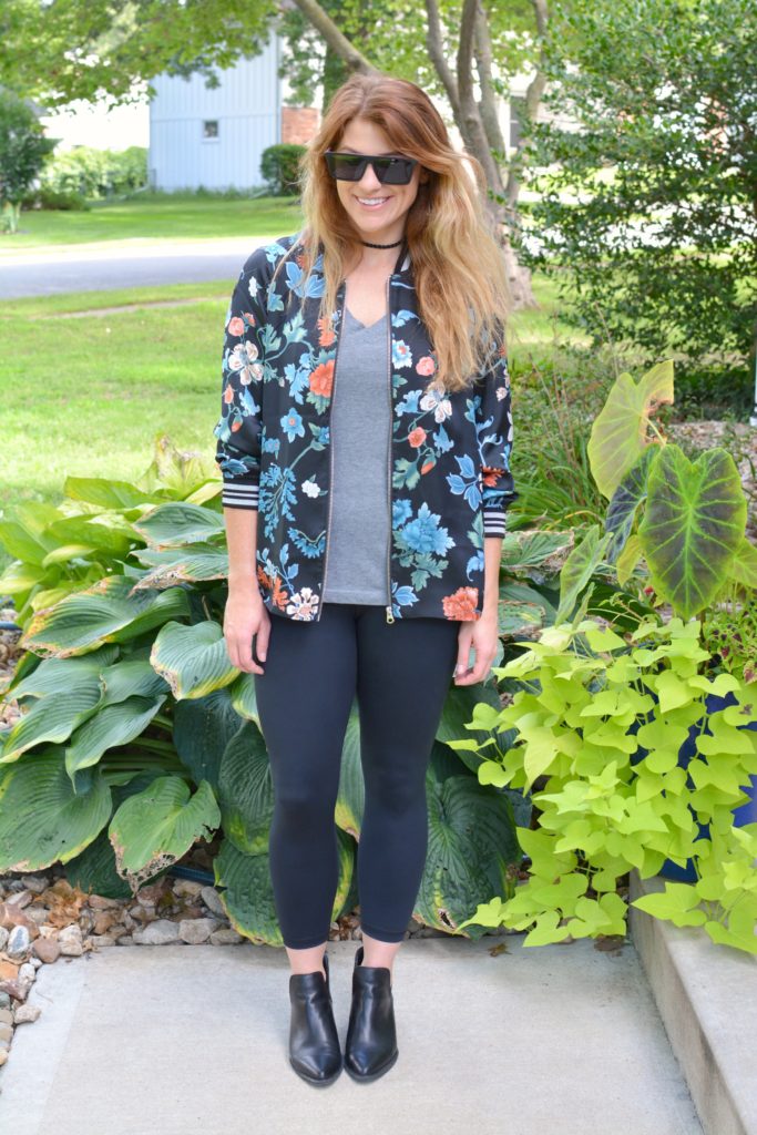 Ashley from LSR wearing a floral bomber jacket from H&M with black leggings and ankle boots