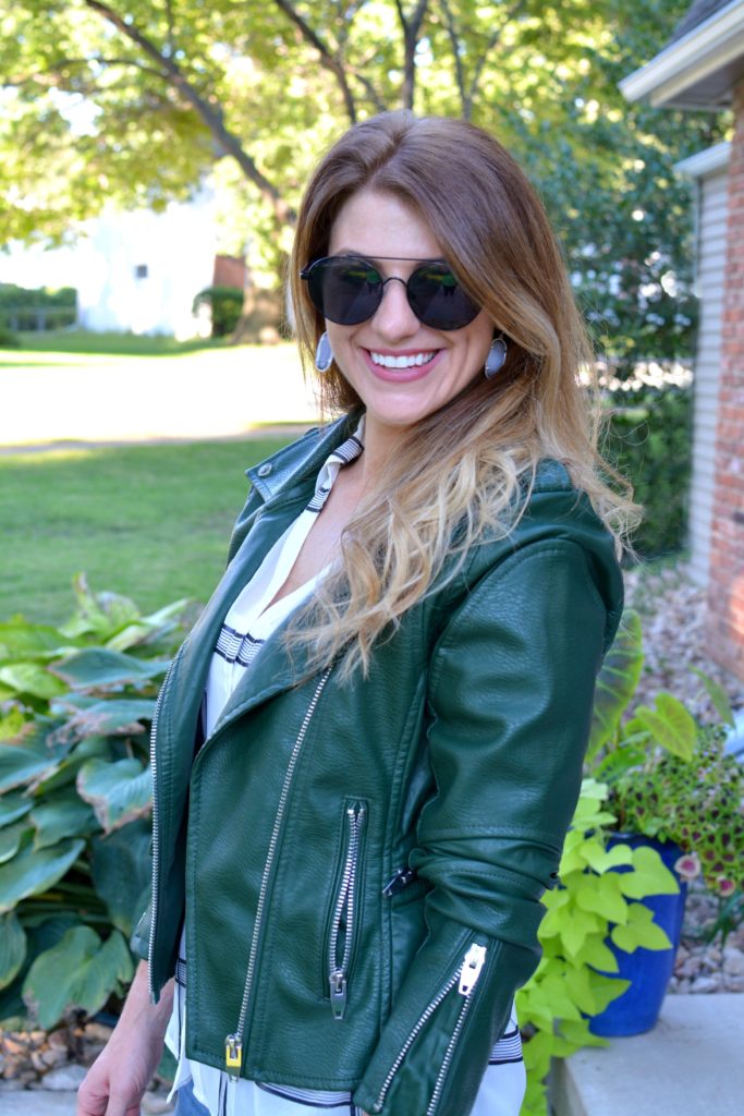 Ashley from LSR in a green leather jacket and a sheer windowpane blouse