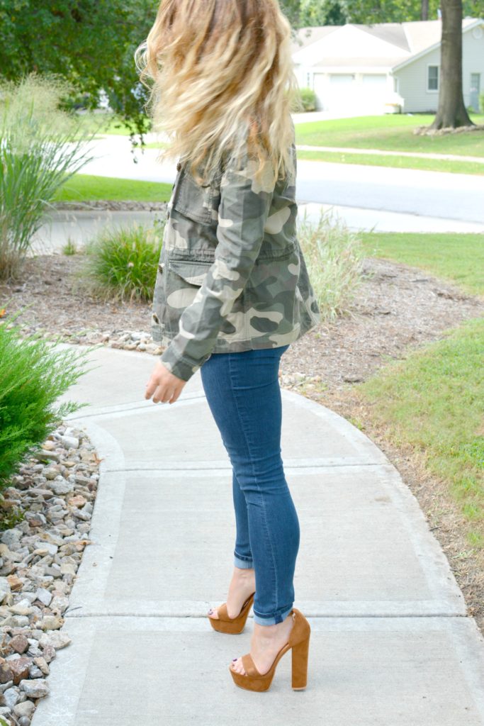 Ashley from LSR in a camo jacket, striped tank, and platform sandals