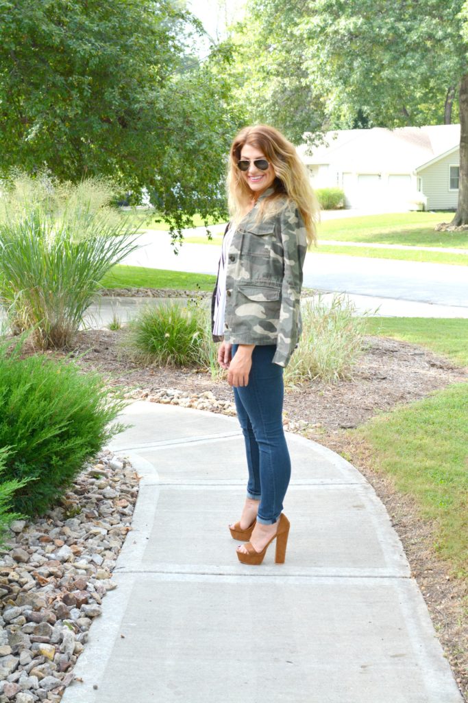 Ashley from LSR in a camo jacket, striped tank, and platform sandals